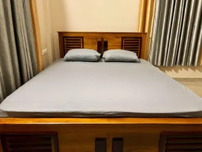a bed with two pillows on top of it at Saraa Homes Fully Furnished 2BHK Apartment in Kulattūr