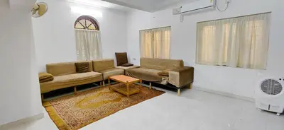 a living room with two couches and a table at Guruvayur Agraharam Homestay in Guruvāyūr