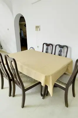 a table and chairs with a yellow table cloth on it at Guruvayur Agraharam Homestay in Guruvāyūr
