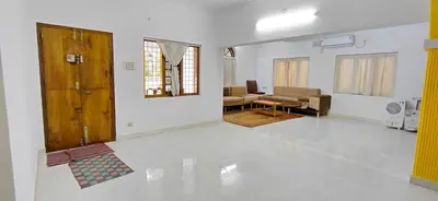 a living room with a couch and a table at Guruvayur Agraharam Homestay in Guruvāyūr