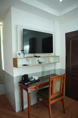 a desk with a television and a chair in a room at Shola Heaven Resort in Kanthalloor