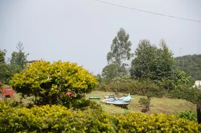 a field with a group of boats in the grass at Shola Heaven Resort in Kanthalloor