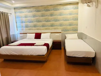 a bedroom with two beds and a painting on the wall at Shola Heaven Resort in Kanthalloor