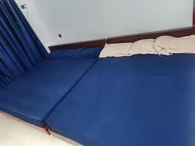 a bed in a room with blue sheets at Poonthanam guest house in Guruvāyūr
