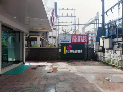 a building with a sign that says have war zone rooms at Poonthanam guest house in Guruvāyūr