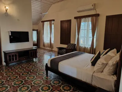 a bedroom with a bed and a flat screen tv at The Estate Bay by Z Vacations in Gonikoppal