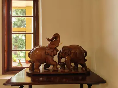 two elephants statue sitting on a table next to a window at The Estate Bay by Z Vacations in Gonikoppal