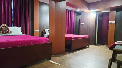 a room with two beds with red sheets and a mirror at Mananya Cottage Ooty in Ooty