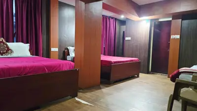 a bedroom with two beds with red sheets and a mirror at Mananya Cottage Ooty in Ooty