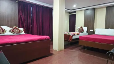 a bedroom with two beds with red sheets at Mananya Cottage Ooty in Ooty