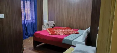 a small bedroom with a bed with a red blanket at Mananya Cottage Ooty in Ooty