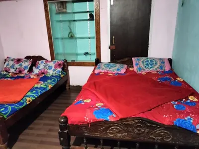 two beds sitting in a room with a window at Laharya couple room in Madikeri