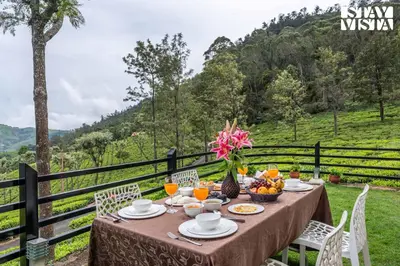 a table with food and fruit on it with a view at StayVista at Sande's Farview with Bonfire in Coonoor