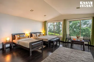 a bedroom with two beds and a large window at StayVista at Sande's Farview with Bonfire in Coonoor