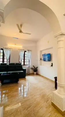 a living room with a black couch and a table at Niel Valley Homestay - Poomala in Mulagunnathukāvu