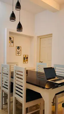 a dining room with a table with a laptop on it at Niel Valley Homestay - Poomala in Mulagunnathukāvu