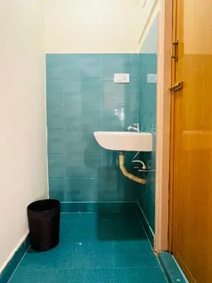 a bathroom with a sink and a blue tiled wall at Green Hill in Coonoor