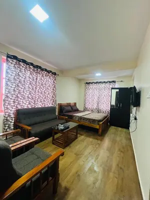 a living room with a couch and a tv at Green Hill in Coonoor