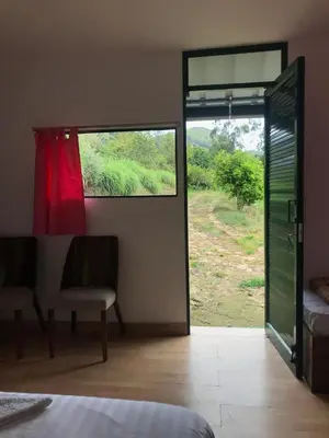a bedroom with a sliding glass door with a window at Lone Tree Creek in Vattavada
