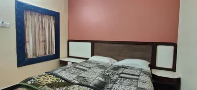 a bedroom with a bed and a window at Hotelsapphire in Ooty
