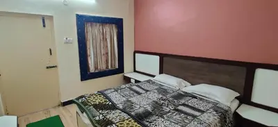 a bedroom with a bed and a picture on the wall at Hotelsapphire in Ooty