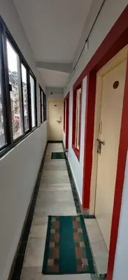 an empty hallway with red and white walls and windows at Hotelsapphire in Ooty