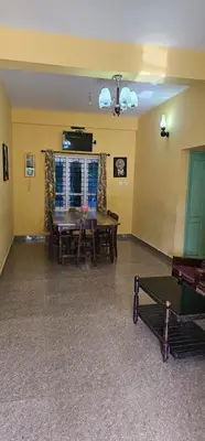 a living room with a table and a couch at The Green Regency Annexe in Munnar