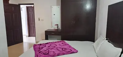 a bedroom with a bed with a pink blanket on it at The Green Regency Annexe in Munnar