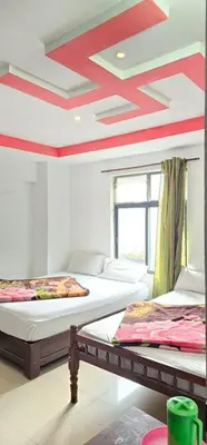 two beds in a room with a red ceiling at The Green Regency Annexe in Munnar
