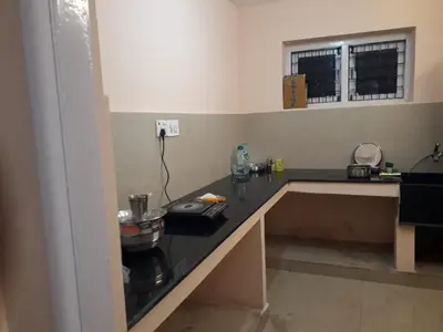 a kitchen with a black counter top in a room at NectorNest in Kodaikānāl