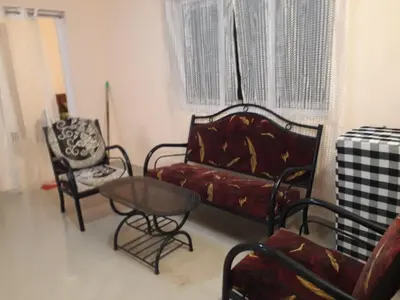 a living room with a couch and two chairs and a table at NectorNest in Kodaikānāl