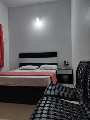 a bedroom with a bed and a chair in it at Fathima Arcade Lodge