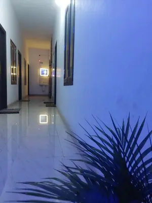 a hallway with blue lighting and a plant at Fathima Arcade Lodge