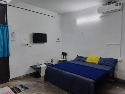 a bedroom with a bed and a tv on the wall at Fathima Arcade Lodge