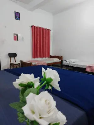 a bouquet of white flowers sitting on a bed at Fathima Arcade Lodge