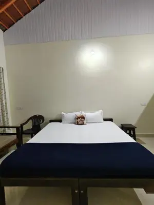 a bed with a teddy bear sitting on top of it at River point homestay in Kushālnagar