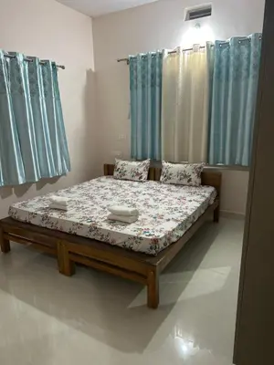 a bed in a room with blue curtains at River point homestay in Kushālnagar