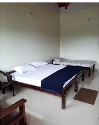a bedroom with two beds in a room at River point homestay in Kushālnagar
