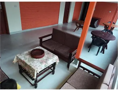 an overhead view of a living room with a couch and a table at River point homestay in Kushālnagar