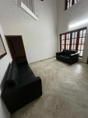 a living room with two black chairs and a couch at Dragster Homes Alwaye in Alwaye