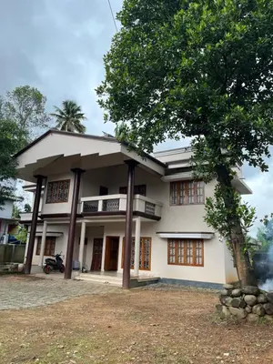 a building with a tree in front of it at Dragster Homes Alwaye in Alwaye