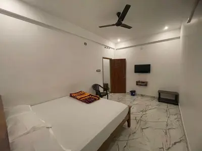 a bedroom with a bed and a ceiling fan at LunaBloom Stays in Marayoor