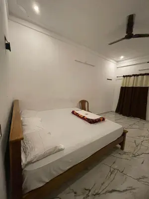 a white bed in a room with a table on it at LunaBloom Stays in Marayoor