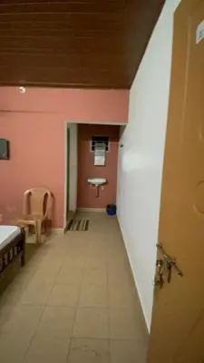 a hallway with a toilet in a room with pink walls at LunaBloom Stays in Marayoor