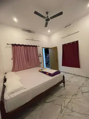 a bedroom with a bed with a ceiling fan at LunaBloom Stays in Marayoor