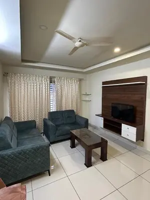 a living room with two couches and a flat screen tv at Falcon Heights in Mysore