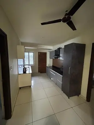 a large kitchen with a ceiling fan in a room at Falcon Heights in Mysore