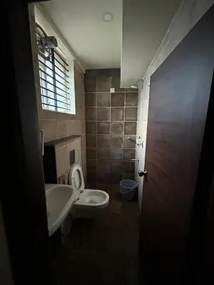 a bathroom with a toilet and a sink at Falcon Heights in Mysore