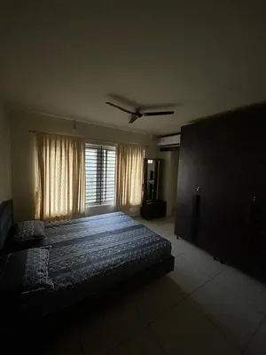 a bedroom with a bed and a window at Falcon Heights in Mysore