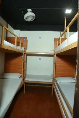a room with three bunk beds in a boat at Ith Pods & Dormitory in Kozhikode